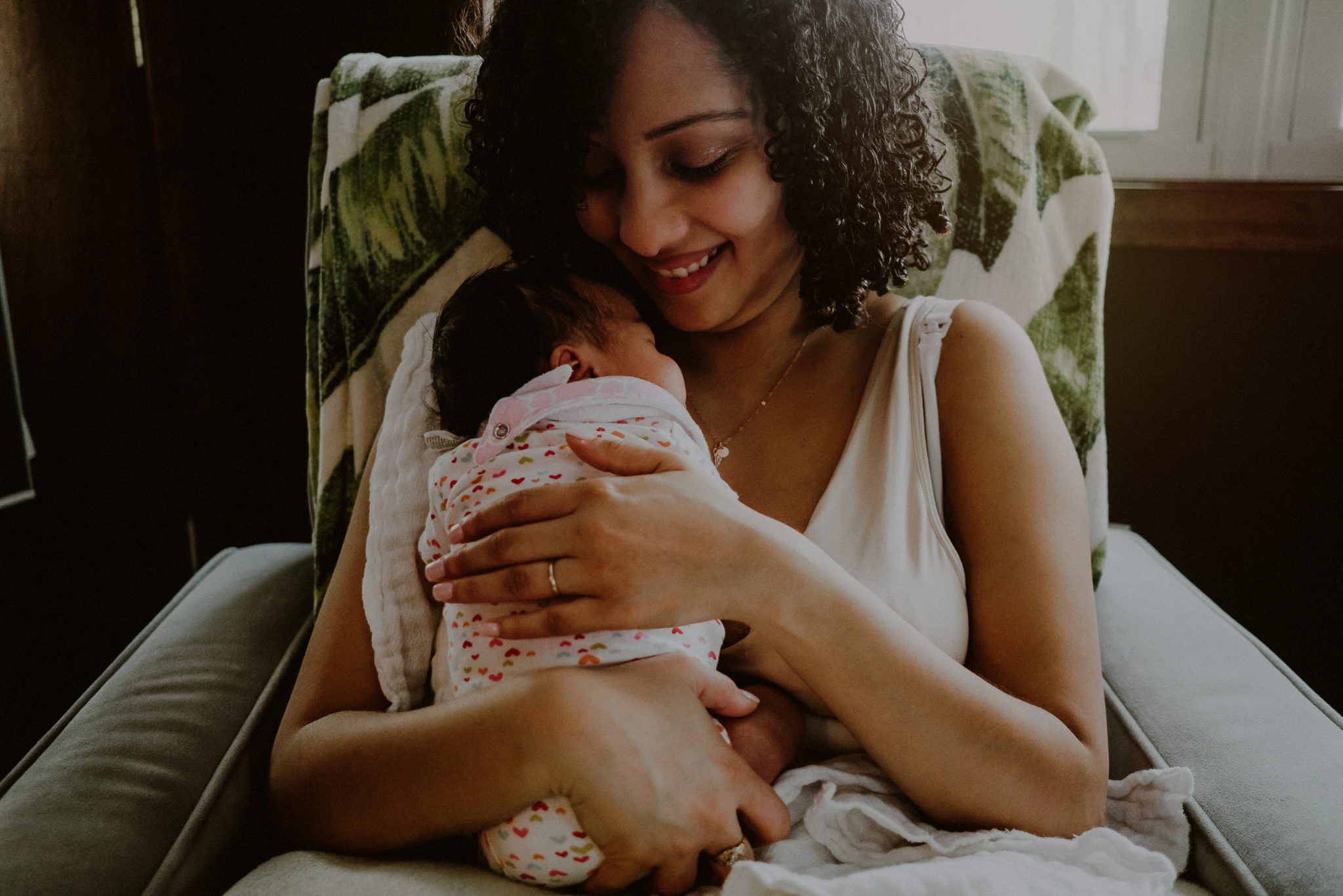 mother holding baby in arms while smiling / gibbsboro nj newborn photos