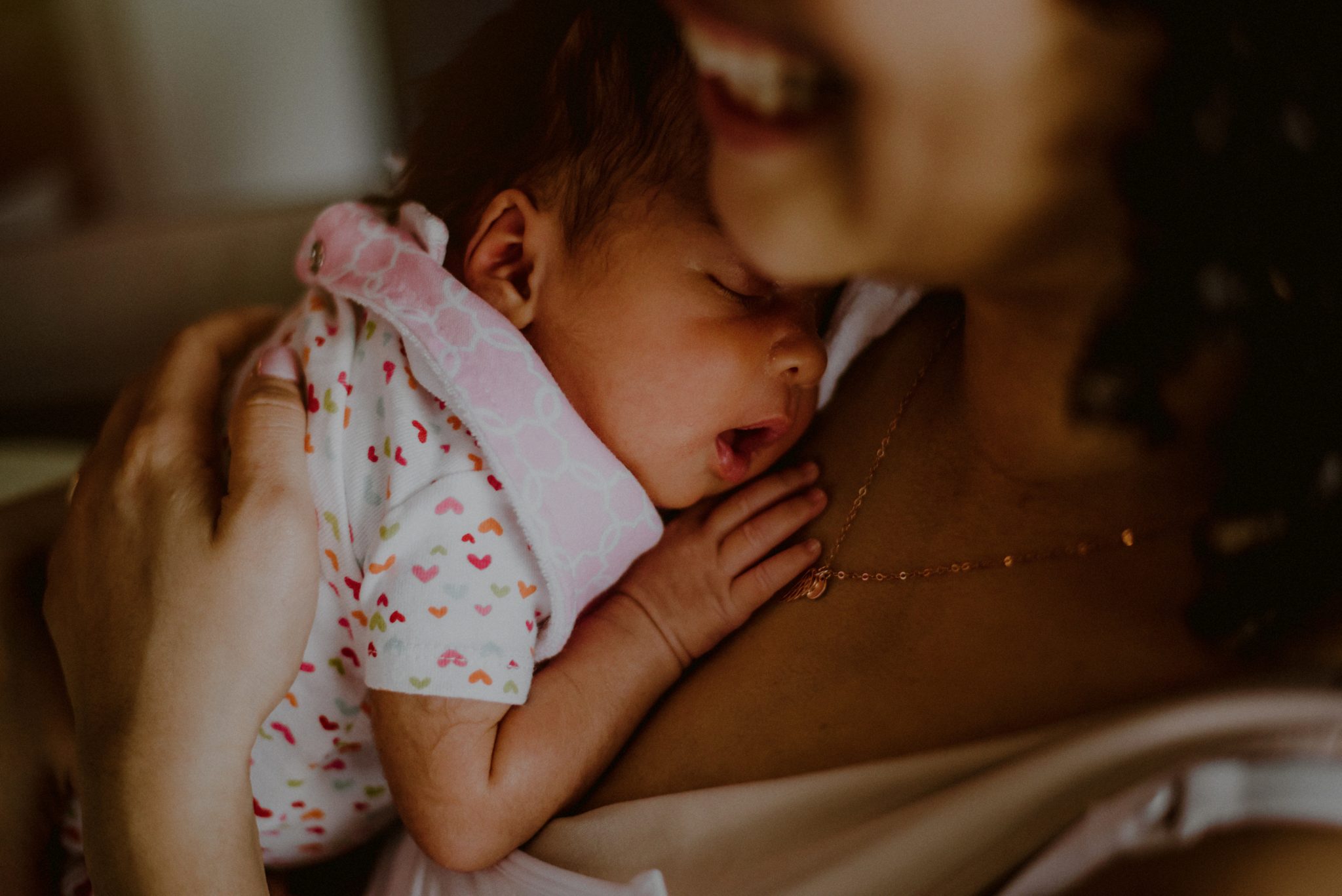 closeup of newborn baby sleeping on mother's chest