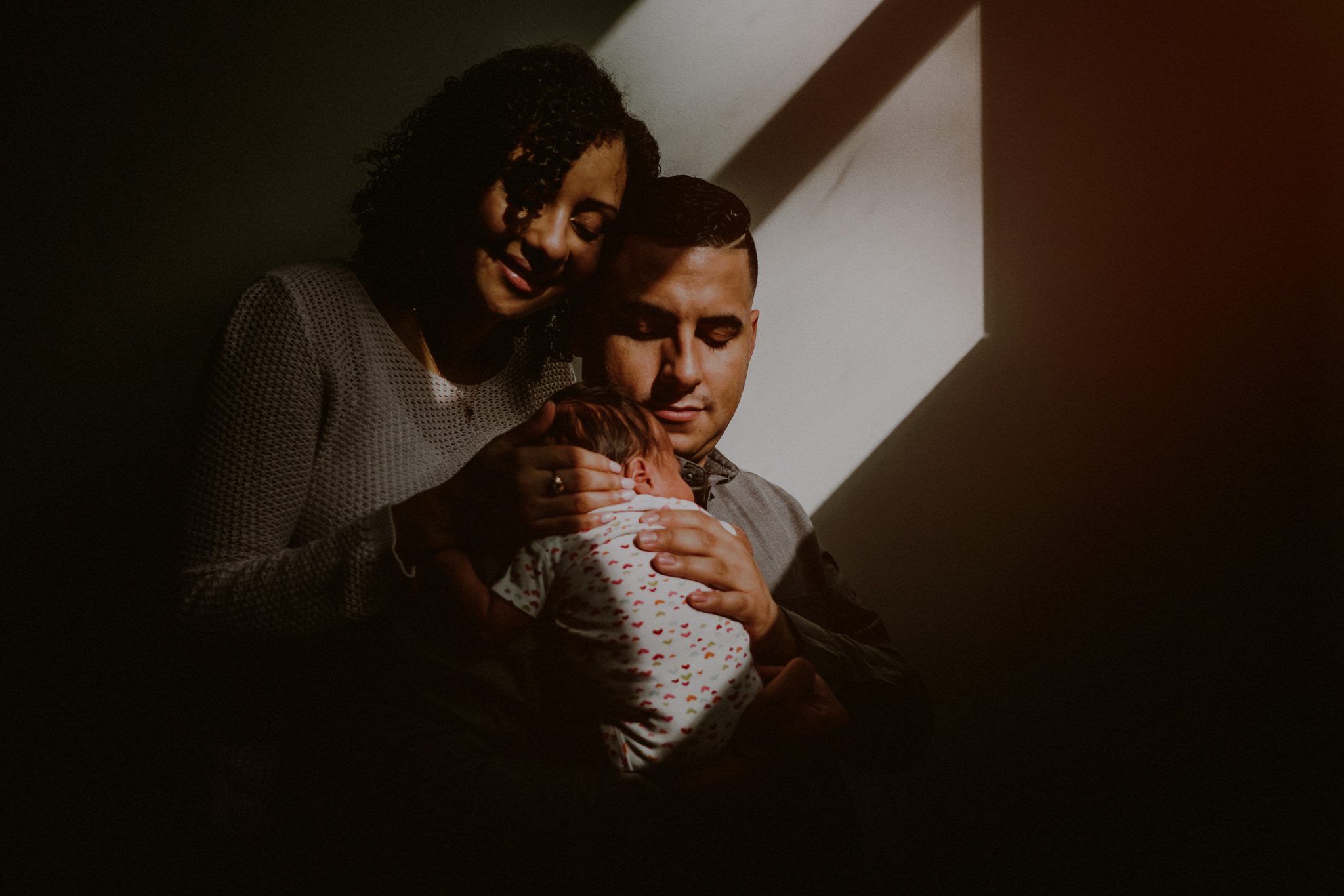 dramatic light portrait of family holding baby in gibbsboro nj
