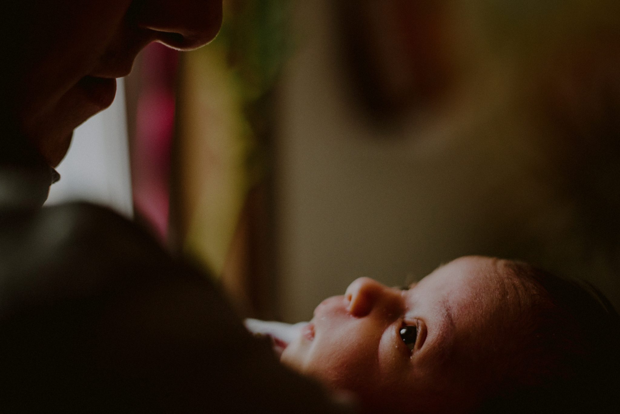 newborn baby tenderly looking up at father