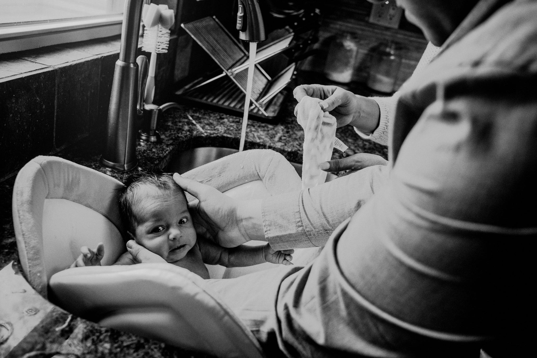 baby's first bath expression in black and white image