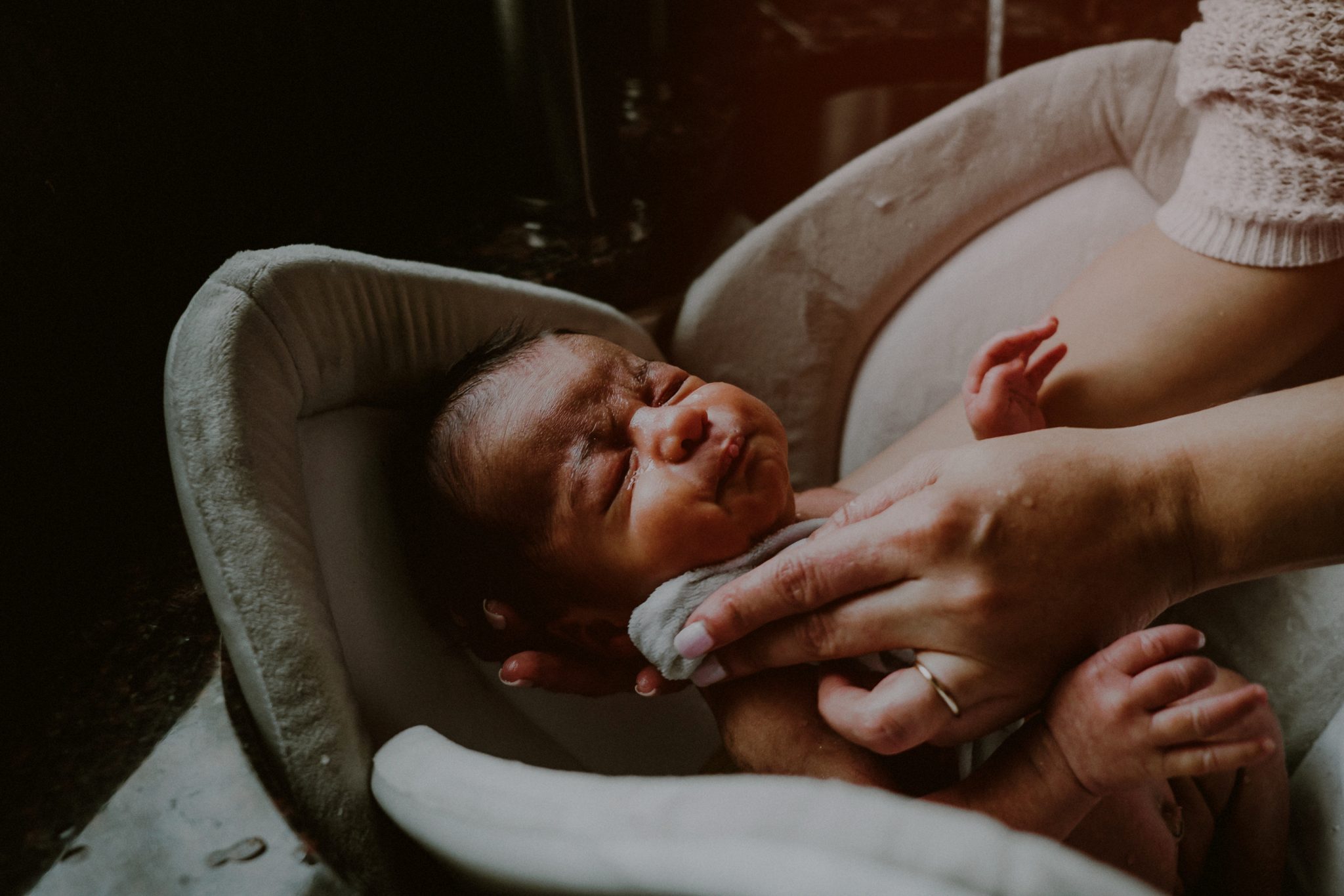 documentary style photo of baby's first bath