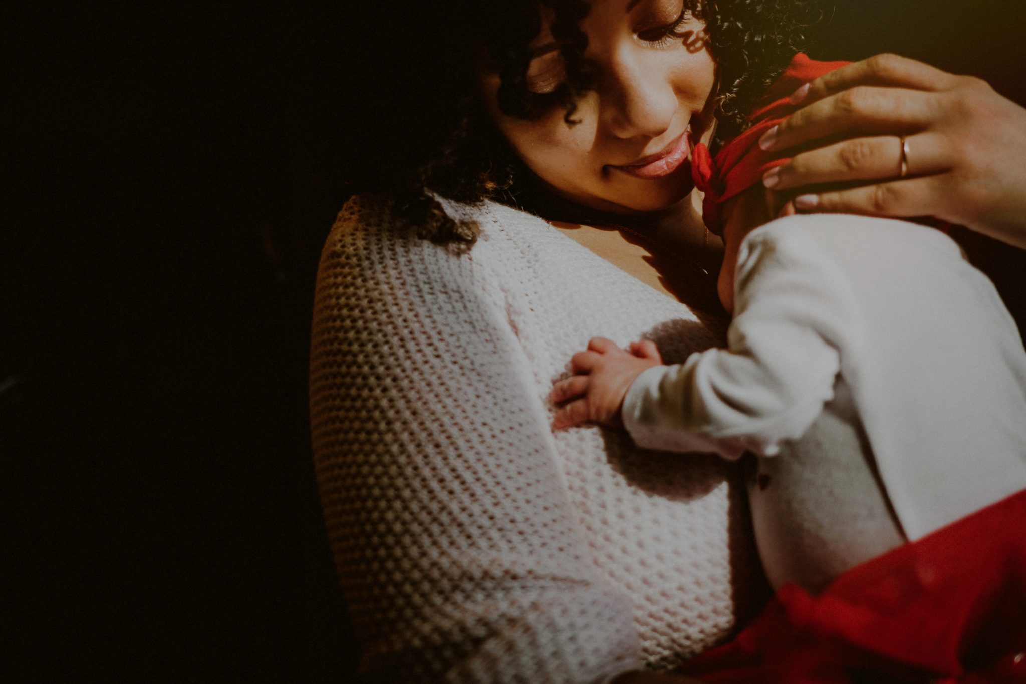 emotional photo of mother holding daughter in harsh light by window