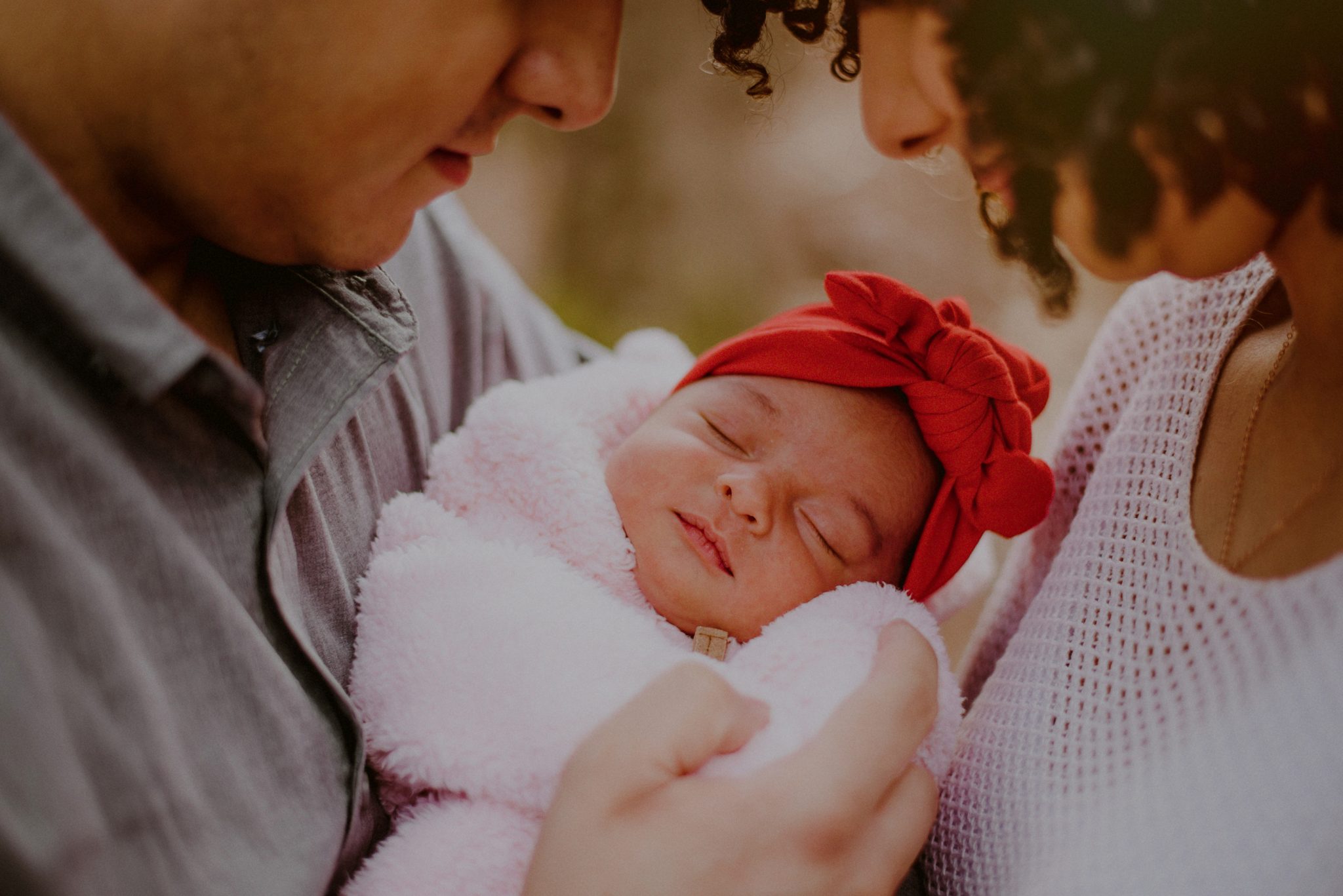 outdoor family portrait of parents holding newborn