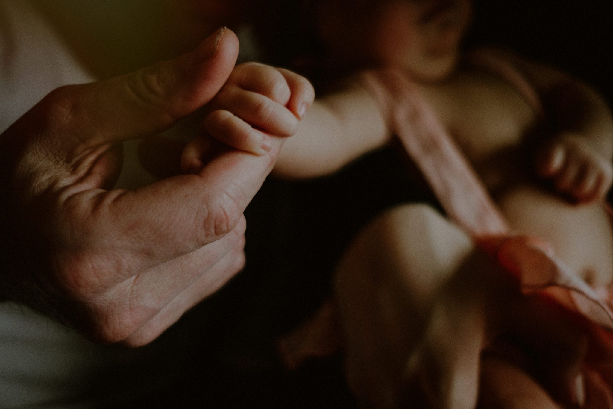 father holding baby's small hands