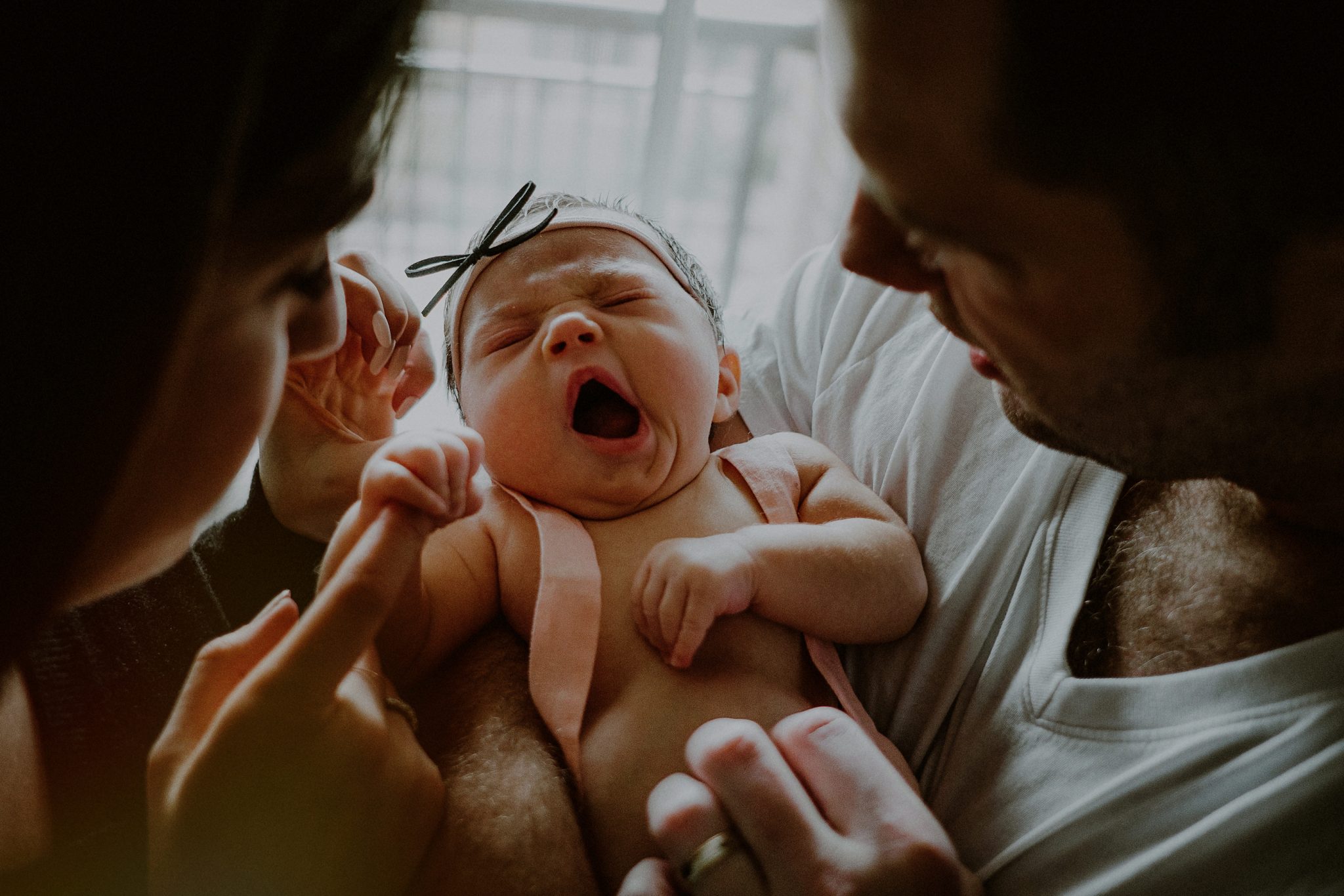 documentary style photos of parents holding baby while yawning