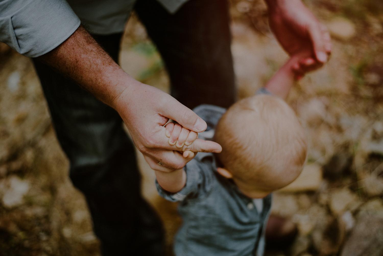 dad teaching son to walk during first birthday photo session