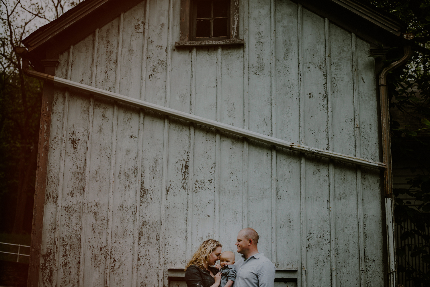 creative family photo posed in front of barn in NJ