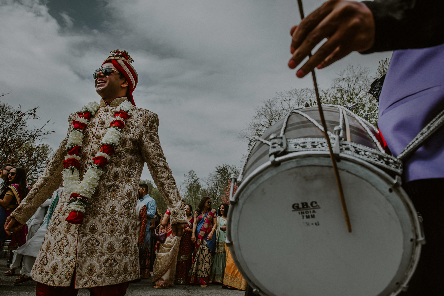 groom dances next to drums in baraat ceremony