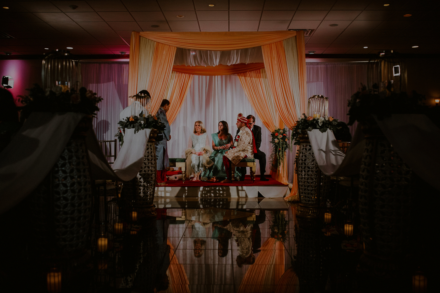 groom and parents under mandap in indian wedding photos