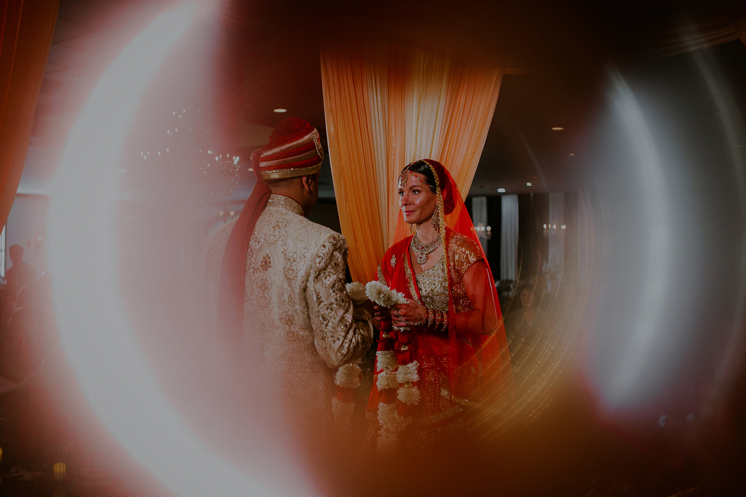 couple exchanges jai mala flower garland during wedding ceremony