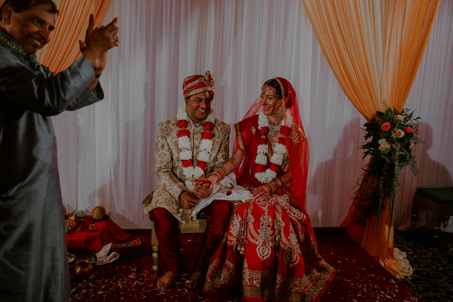 indian bride and groom marry under the mandap