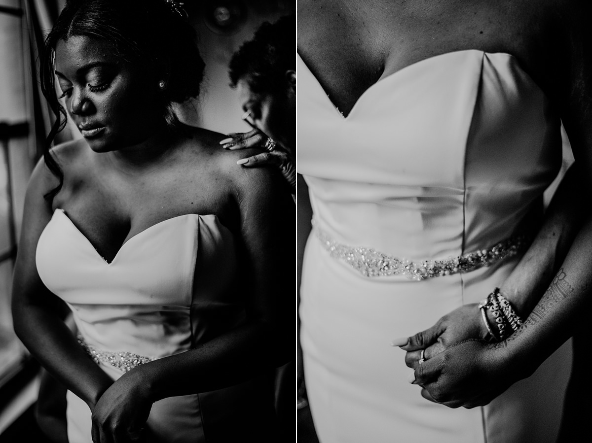 black and white photo of bride putting on wedding dress