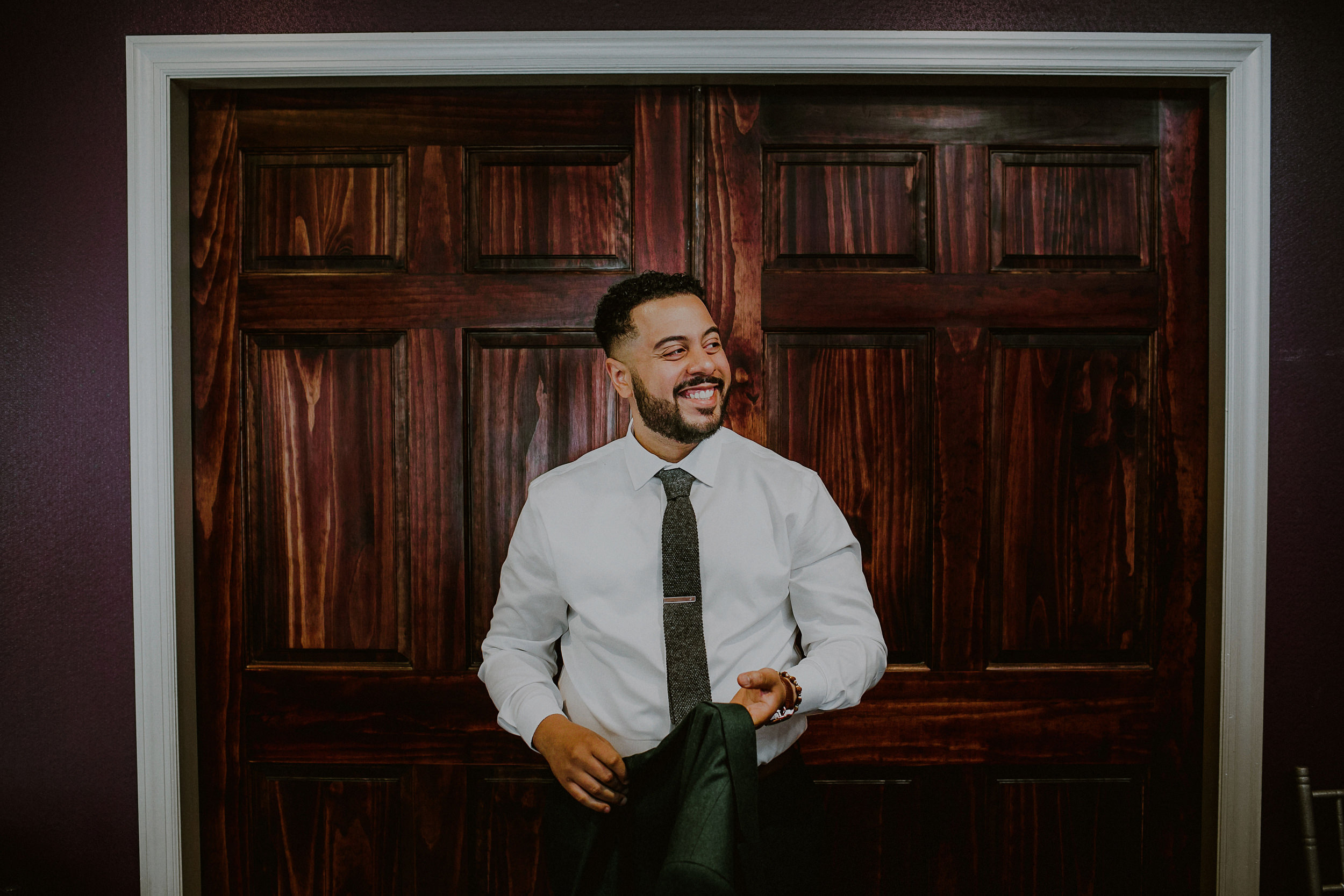 candid groom getting ready for wedding in woodbury ny