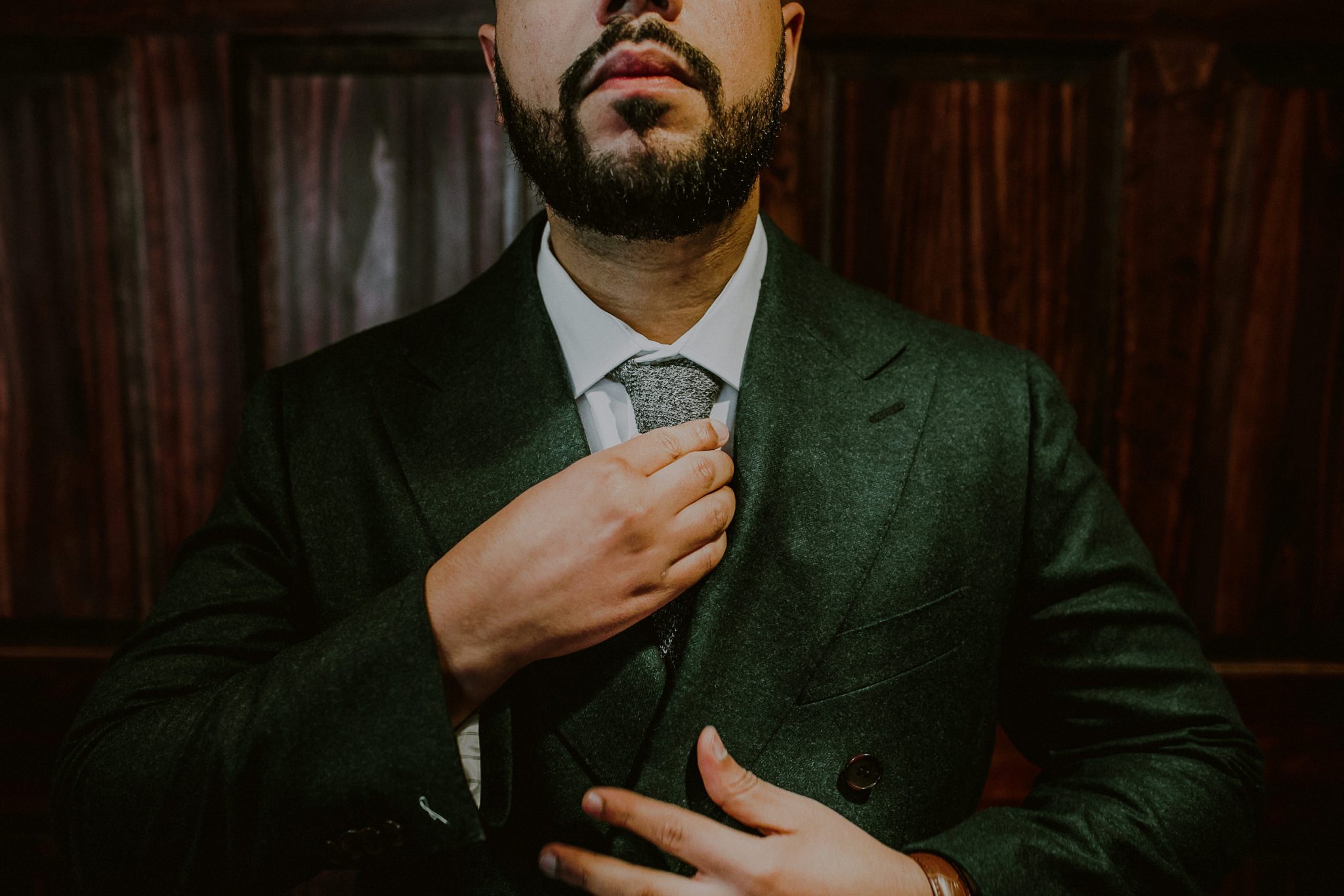 creative photo of well dressed groom in green suit preparing for wedding at fox hollow