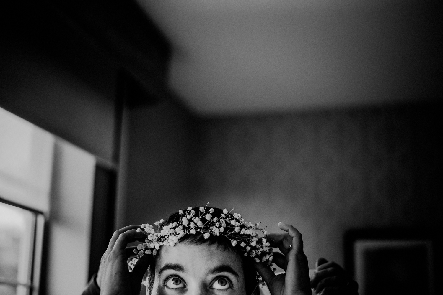 bride putting on flower crown for wedding