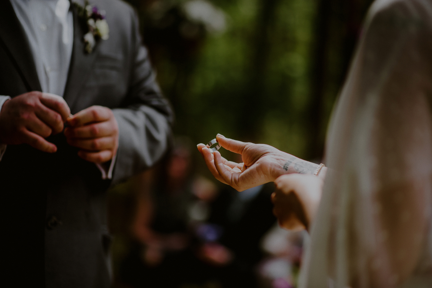 creative wedding photo of bride and groom putting on rings