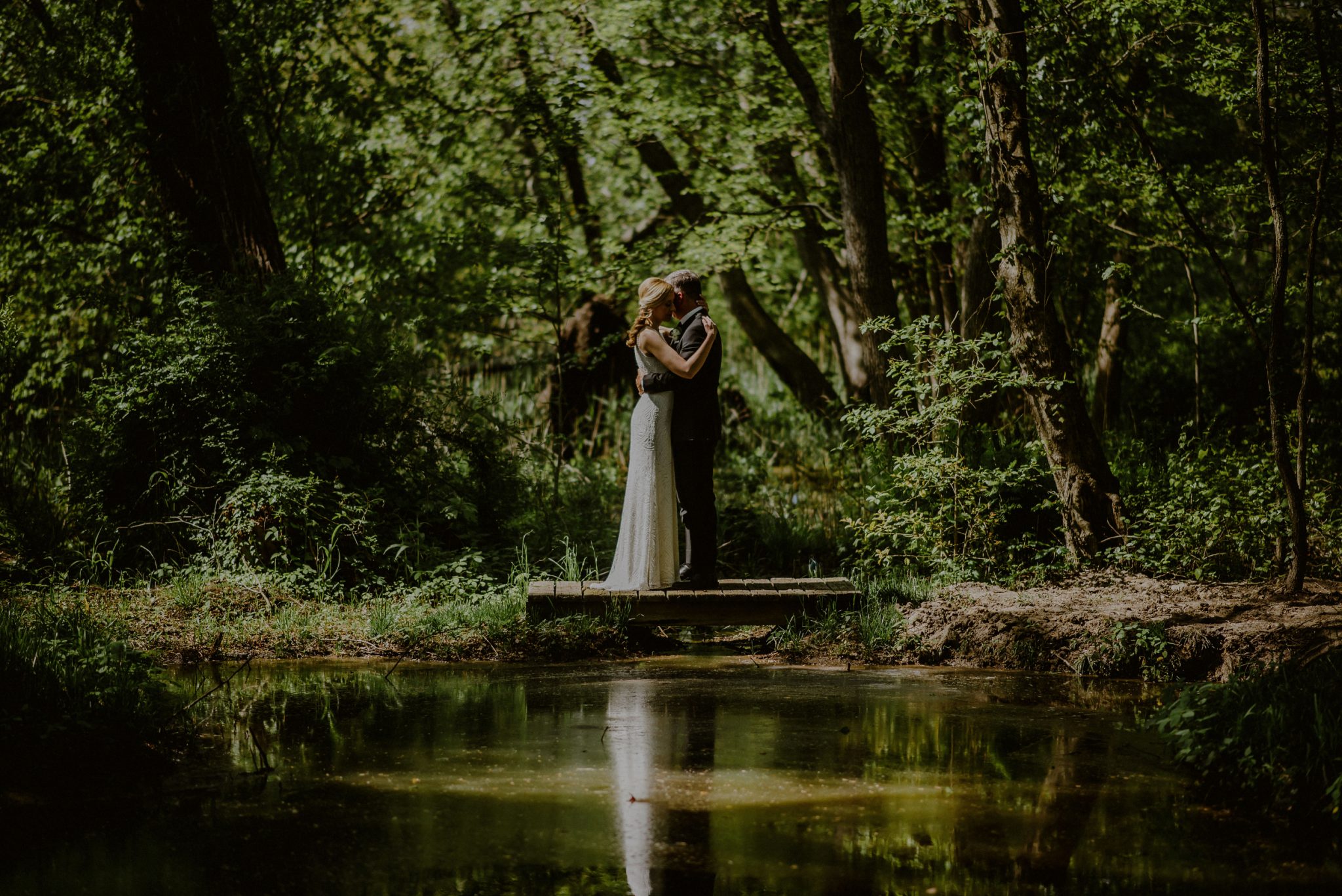 artistic wedding portrait of bride and groom with reflection