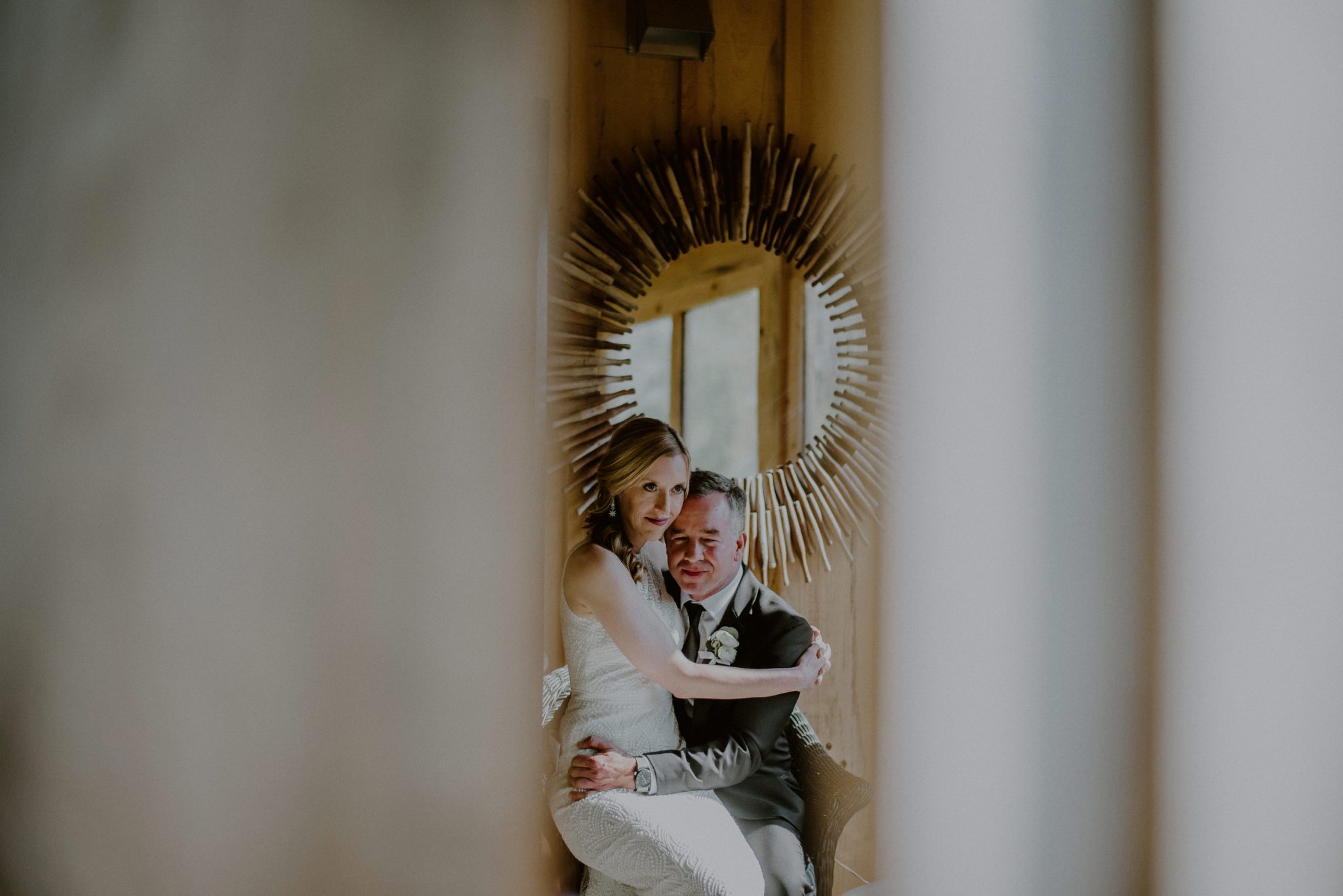 bride and groom snuggle during candid moment before ceremony