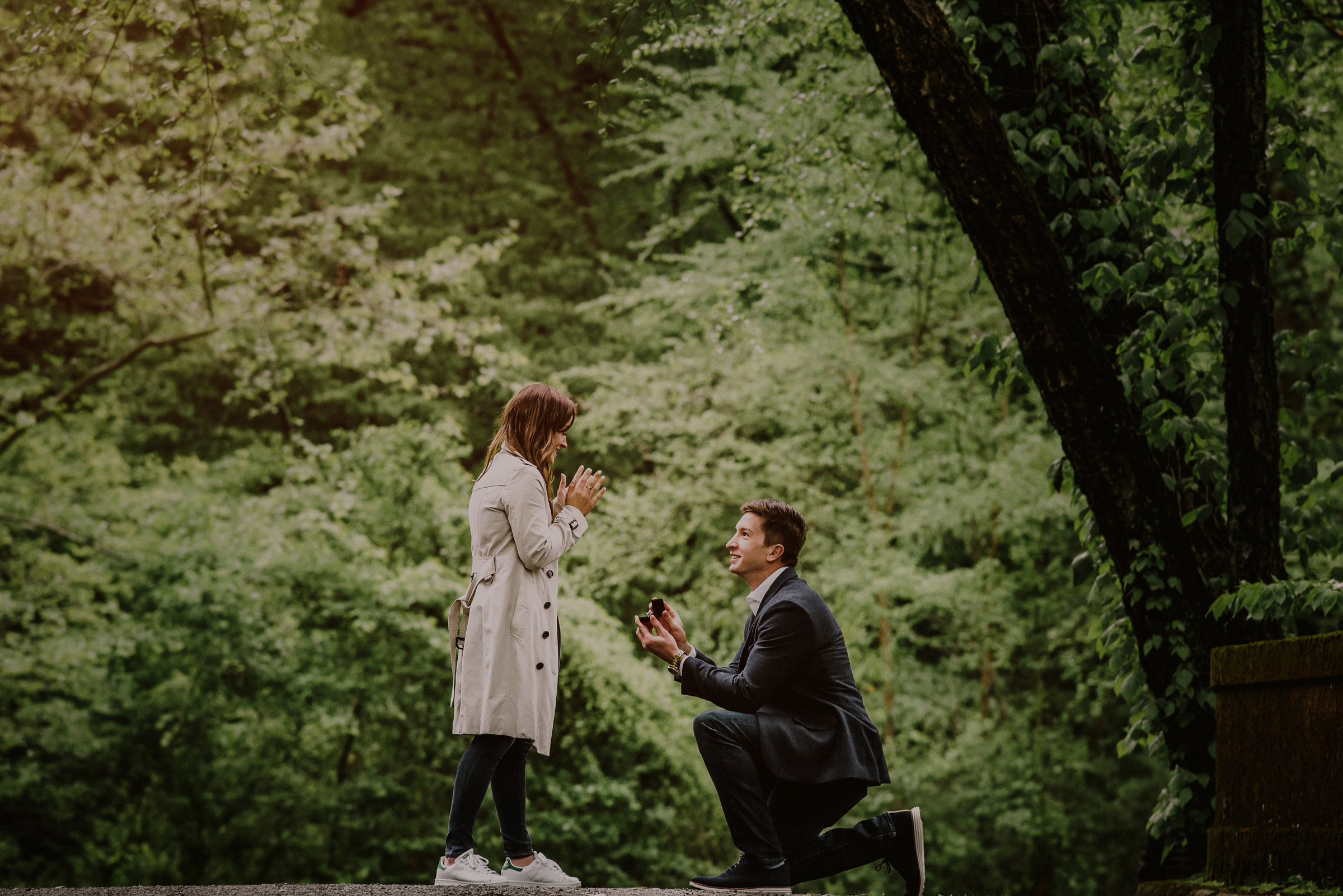 man on his knees proposing in woods