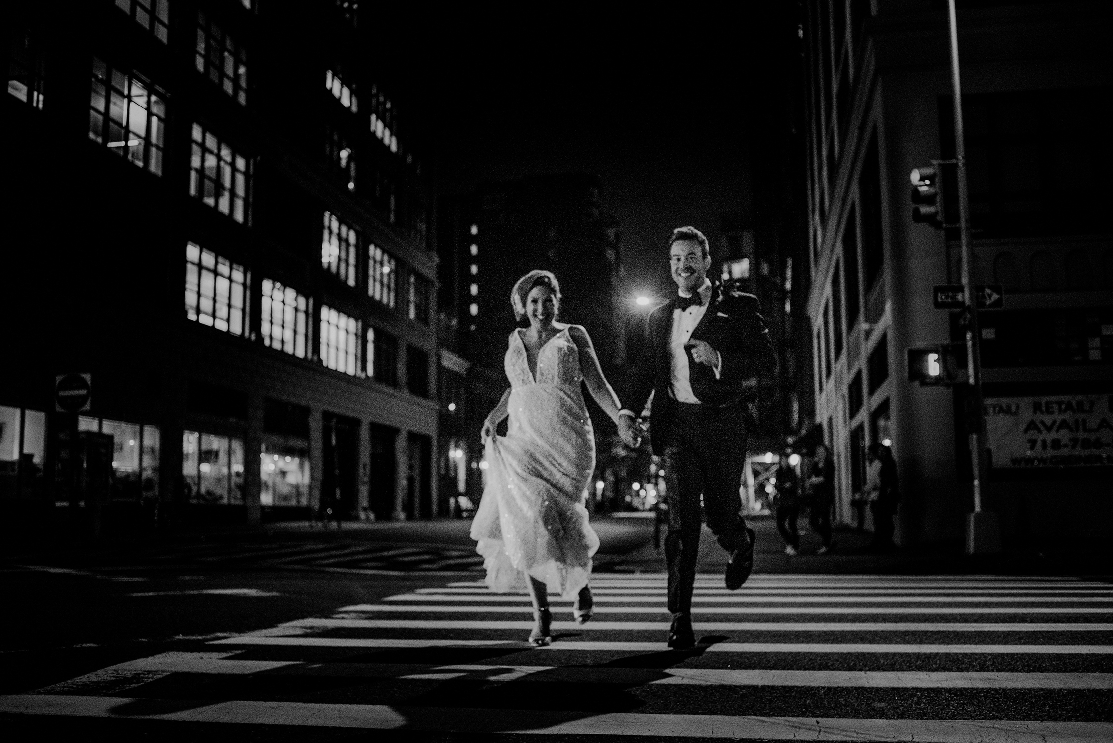 happy couple running through streets of nyc in wedding attire