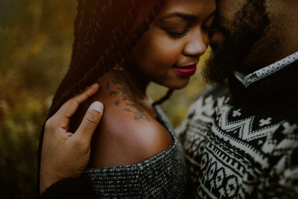 tattooed couple intimately poses for engagement photos