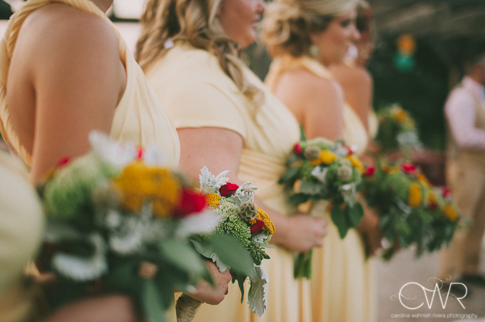 laurita winery wedding ceremony: bridesmaids in yellow dresses holding bouquets