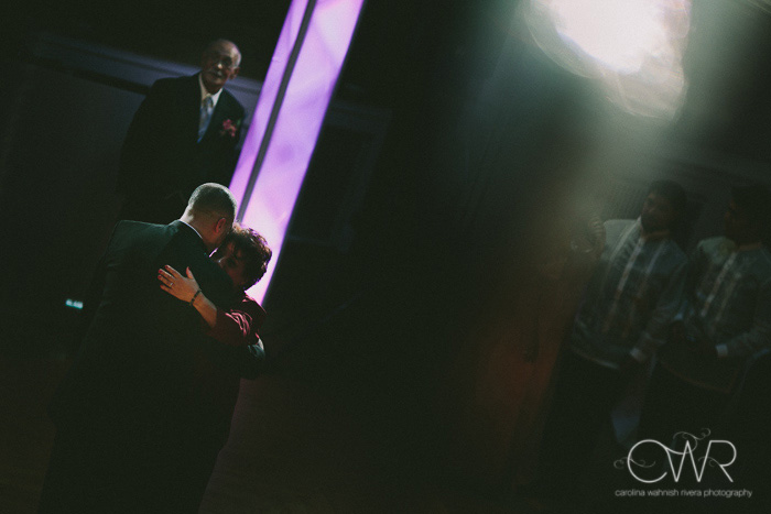candid wedding photography dramatic lighting dance between groom and mother
