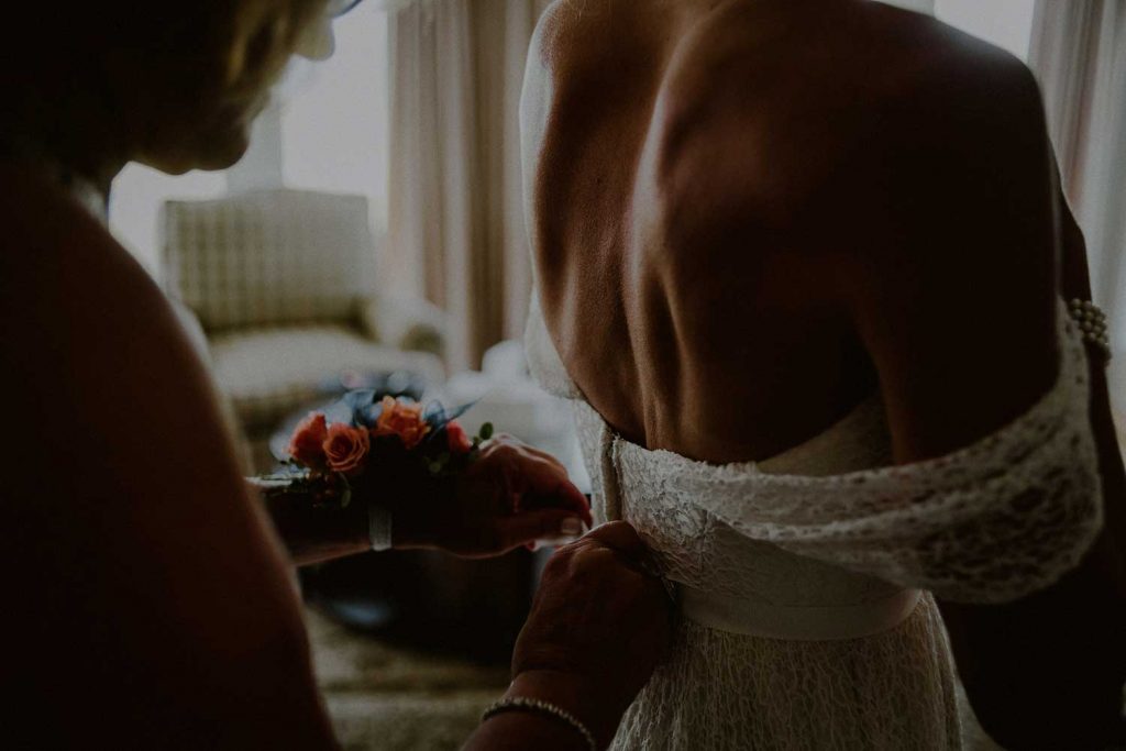 bride ties up wedding dress at bonnet island wedding suite