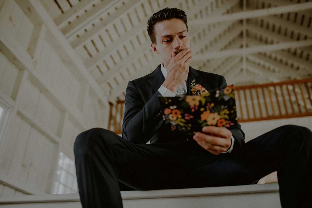 emotional groom while reading card from bride