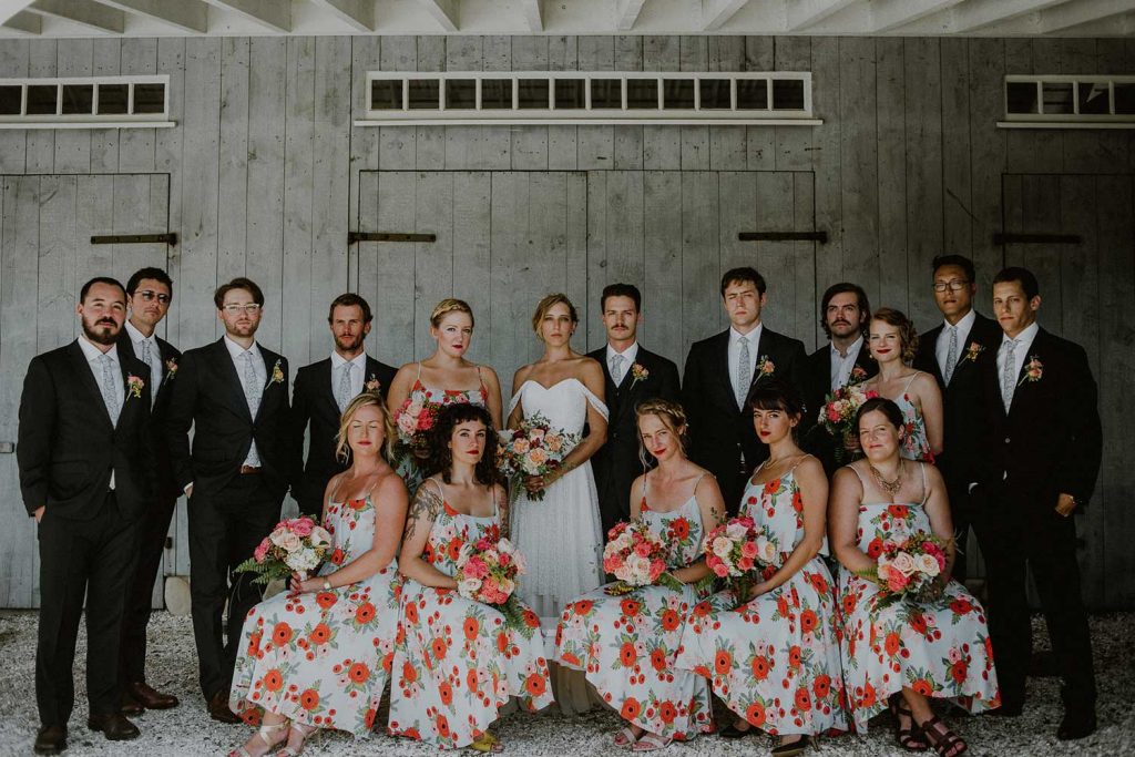 bridal party portrait in front of barn at bonnet island with coordinating floral bridesmaids dresses