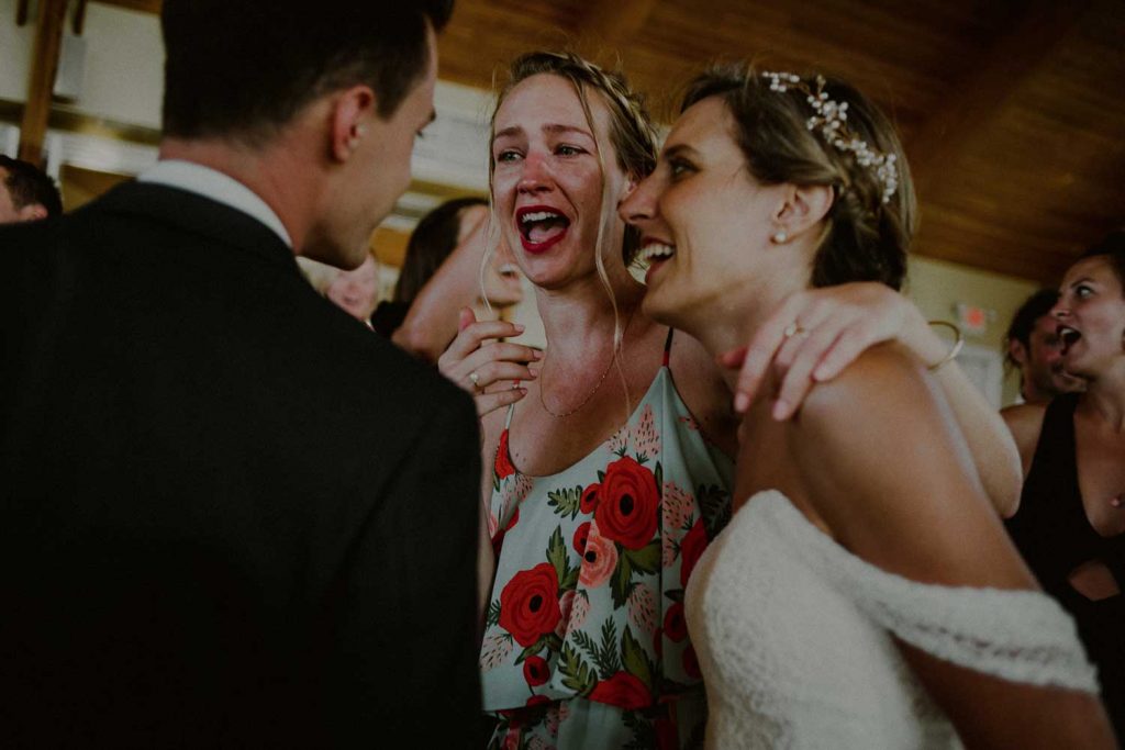 bride and groom laugh with guests at their reception