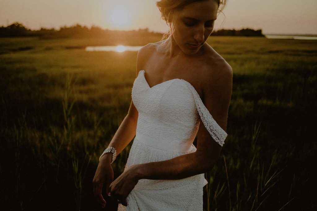 beautiful bride poses for sunset bridal portraits at long beach island wedding