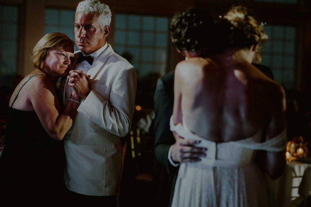 intimate wedding reception moment of couple dancing next to parents