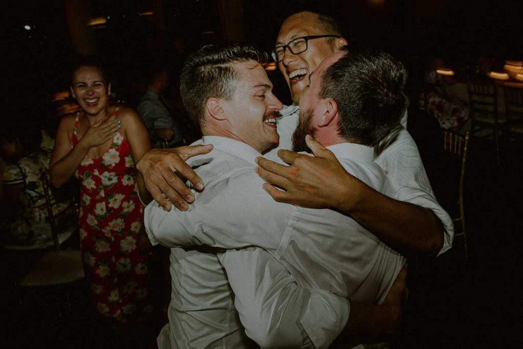 groom dancing with friends at wedding reception