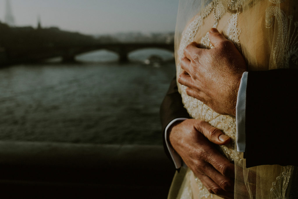 man's hands embracing woman in front of pont alexandre in paris wedding