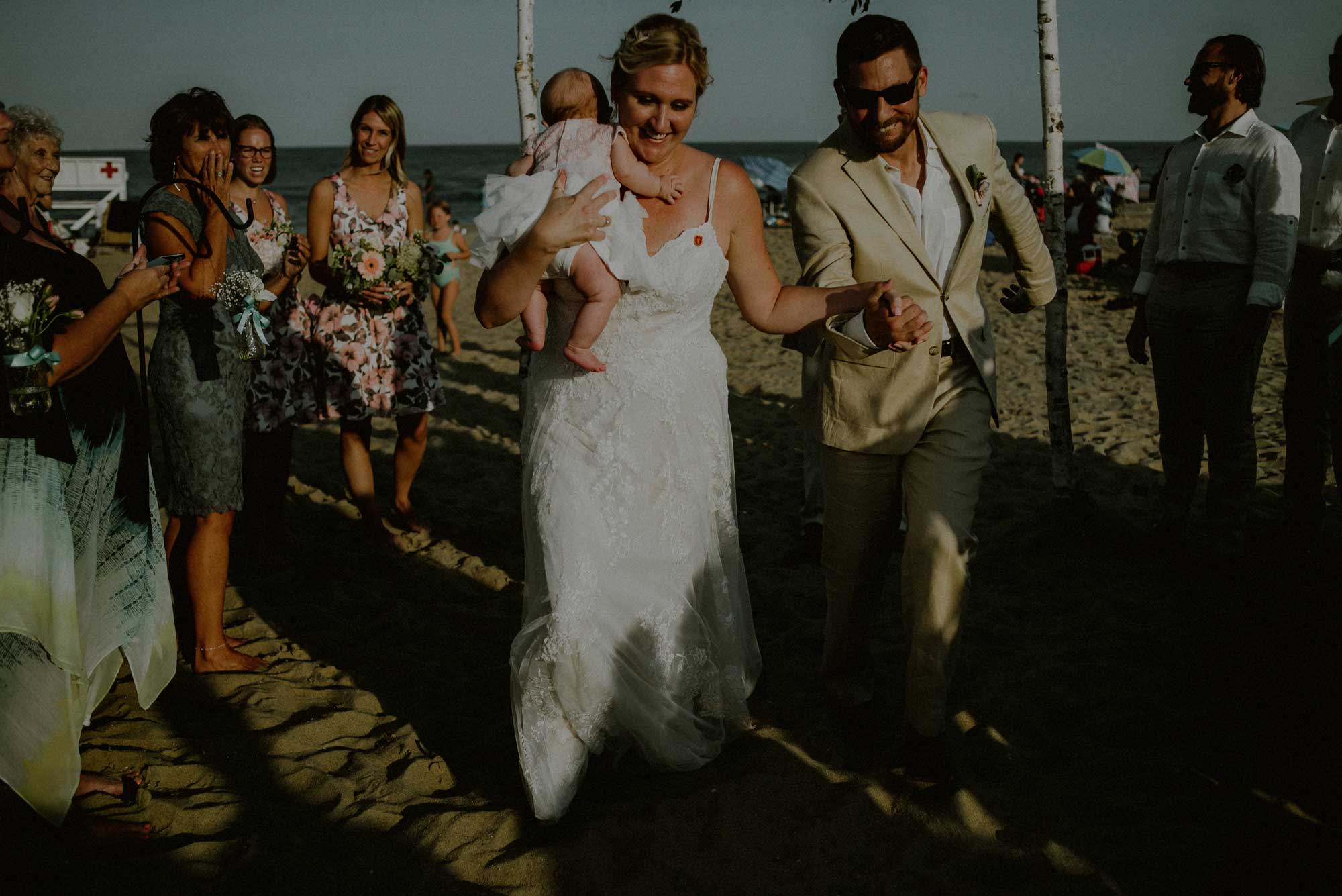 couple with child exit wedding ceremony