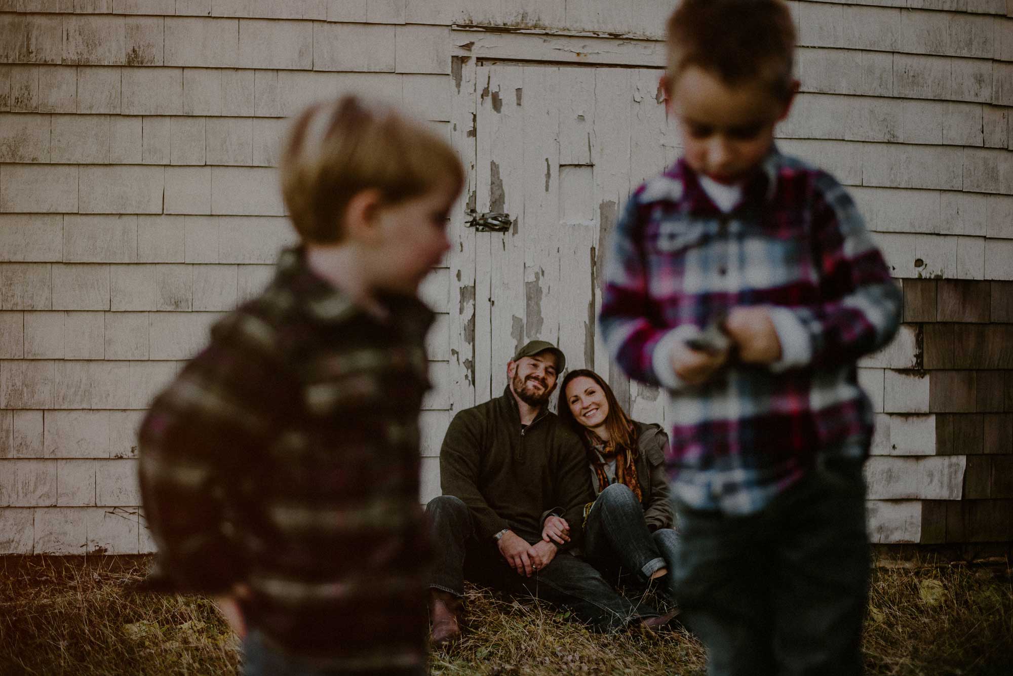 kids in foreground of barn structure and parents in background