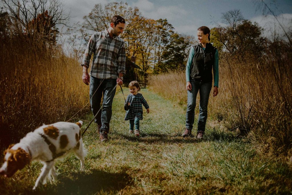 family with dog walking in plaid shirts
