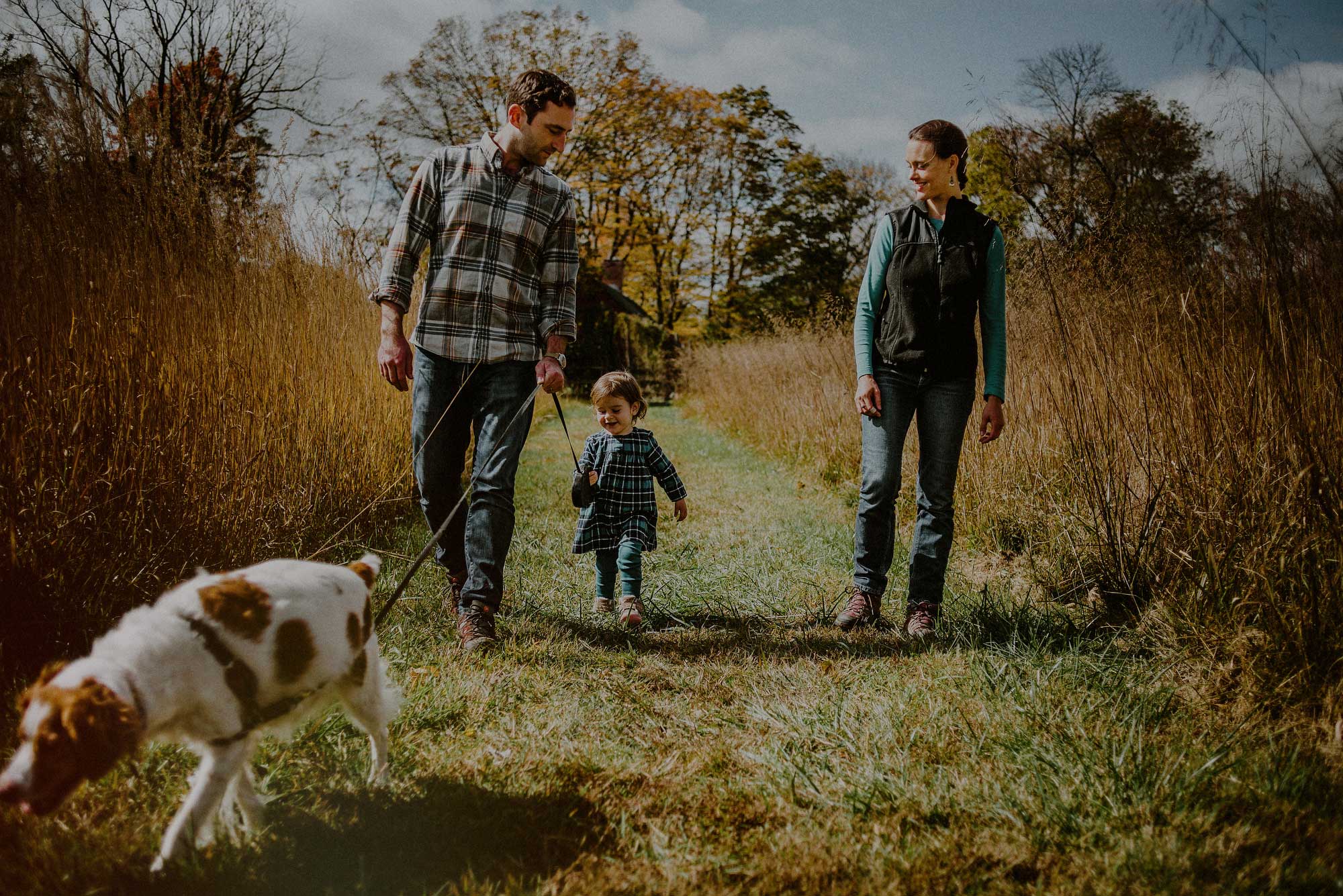 family with dog walking in plaid shirts 