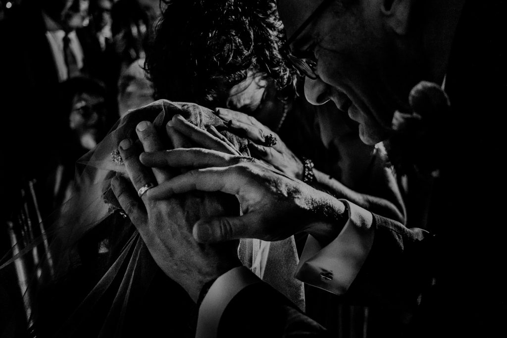 black and white photo of father of the bride blessing and touching brides head during emotional moment by New Jersey Wedding Photographer Carolina Rivera