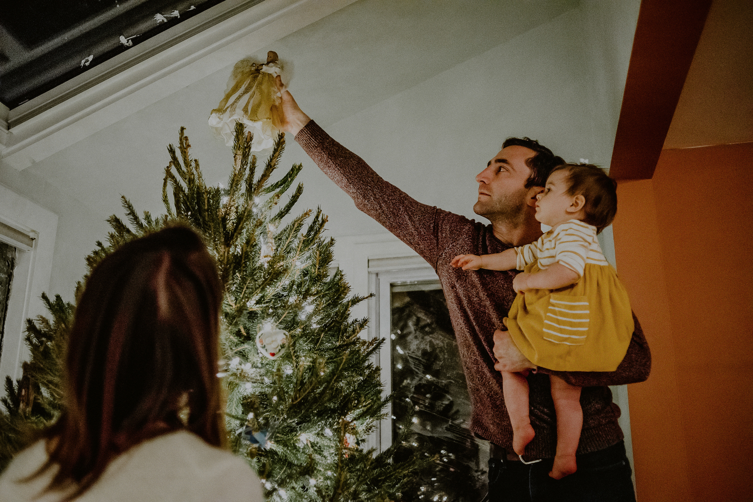 father and daughter putting up christmas tree during day in the life session