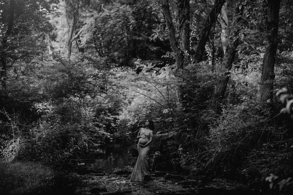 black and white creative portrait of pregnant woman in woods