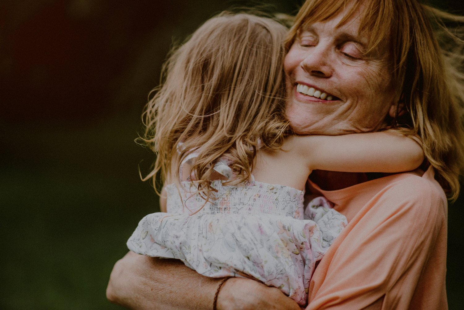 happy grandmother hugging grand daughter with eyes closed