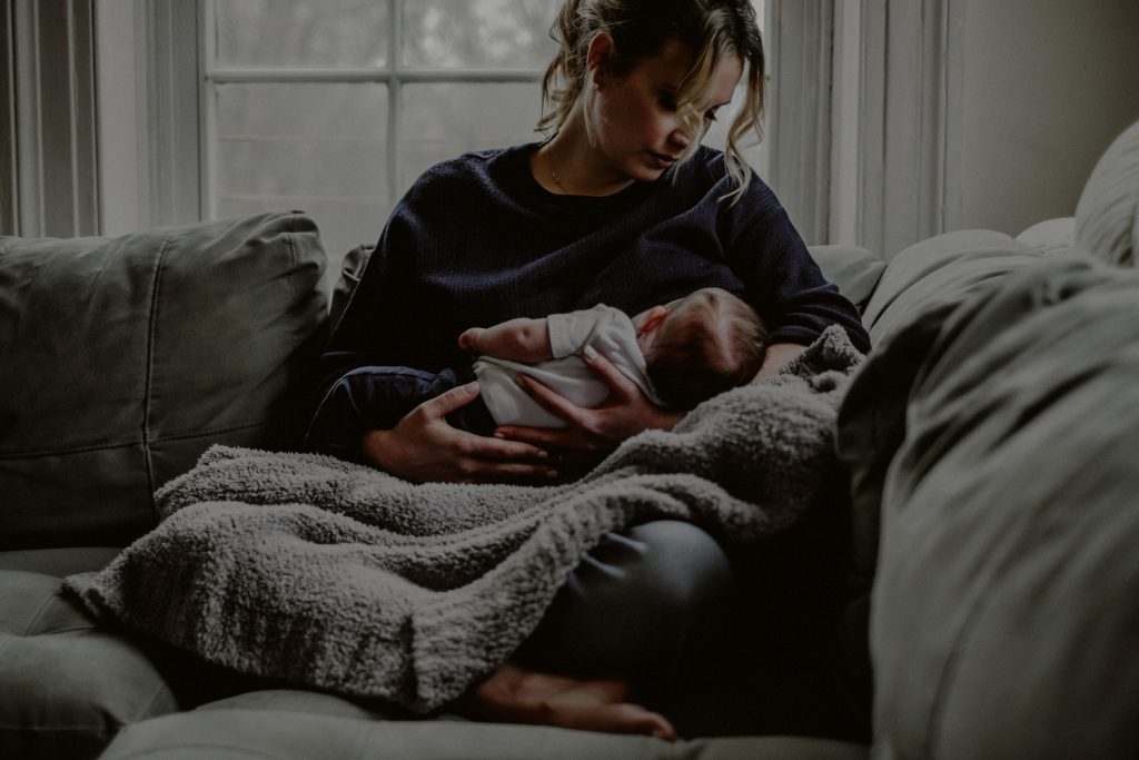 mother breastfeeding newborn in living room