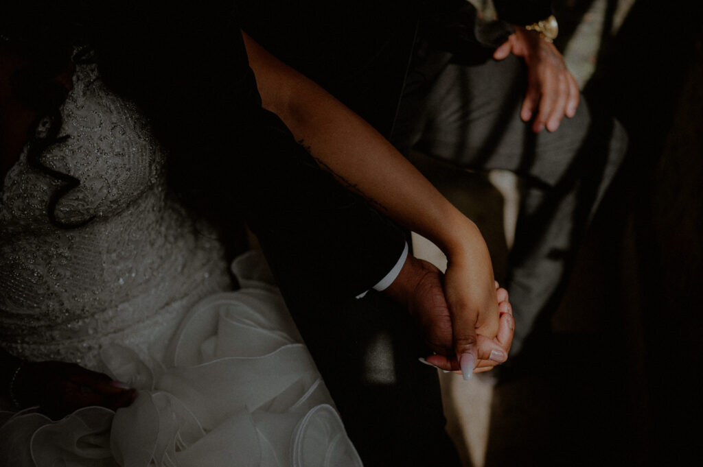 wedding couple holding hands in sunlight
