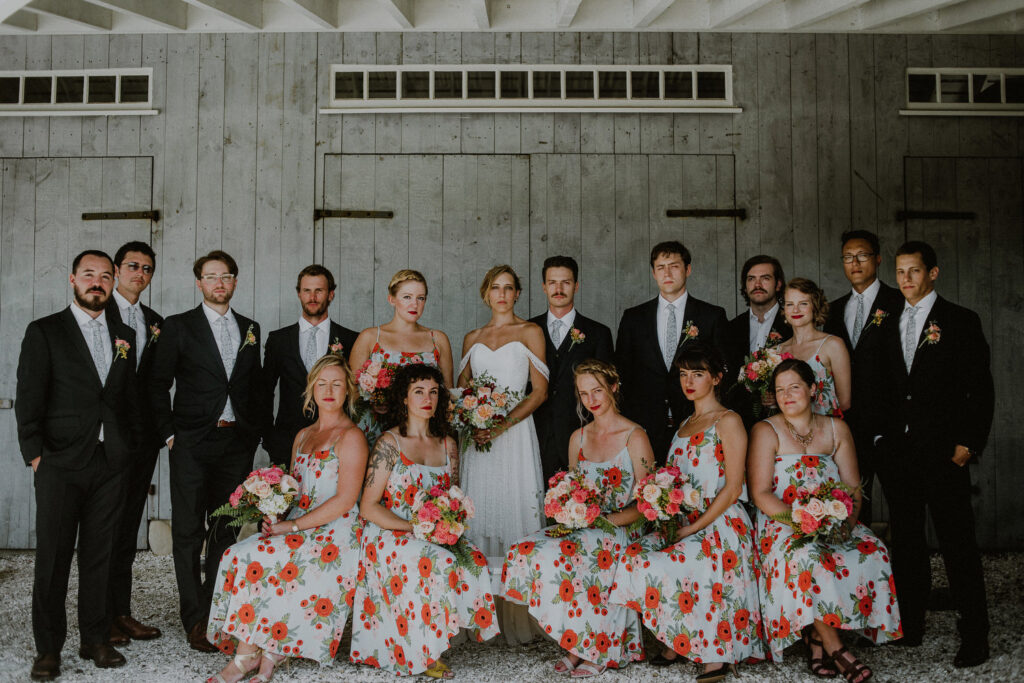 bridal party posed in front of barn-like structure at Bonnet Island Estate