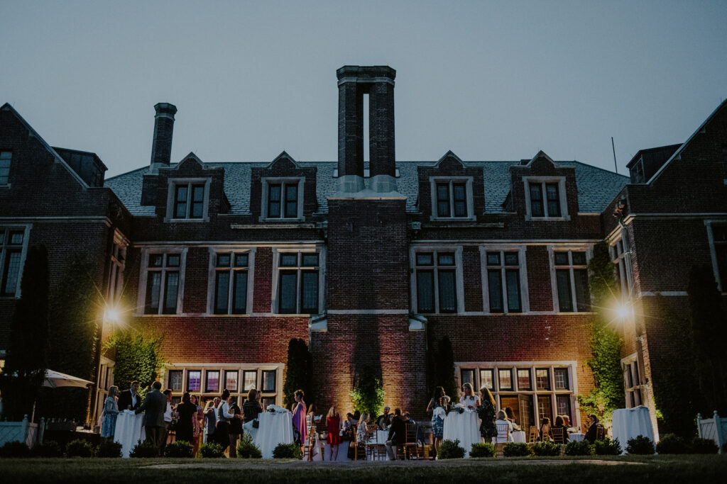 back outdoor facade of mansion at natirar at dusk during wedding reception - Natirar Wedding Photos