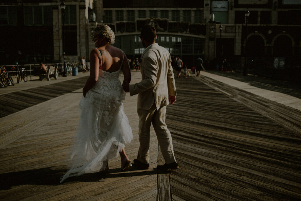candid portrait of couple with back facing the camera on asbury park boardwalk