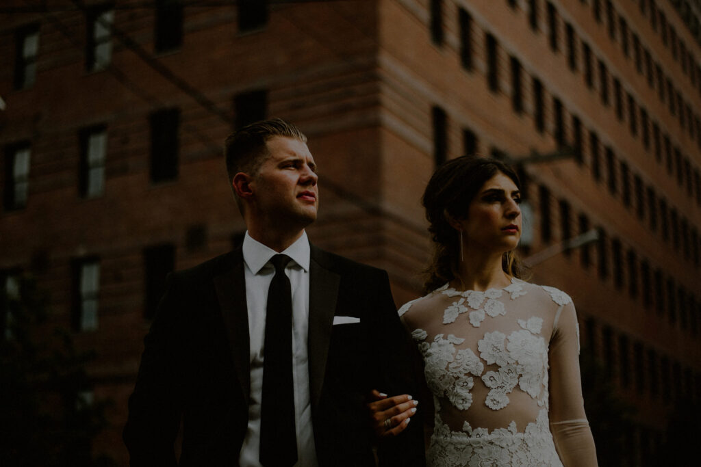 bride and groom portrait in urban setting in front of brick building in jersey city